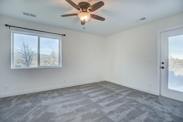 carpeted empty room with ceiling fan and a healthy amount of sunlight