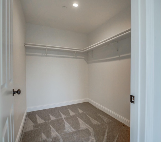 spacious closet featuring dark carpet