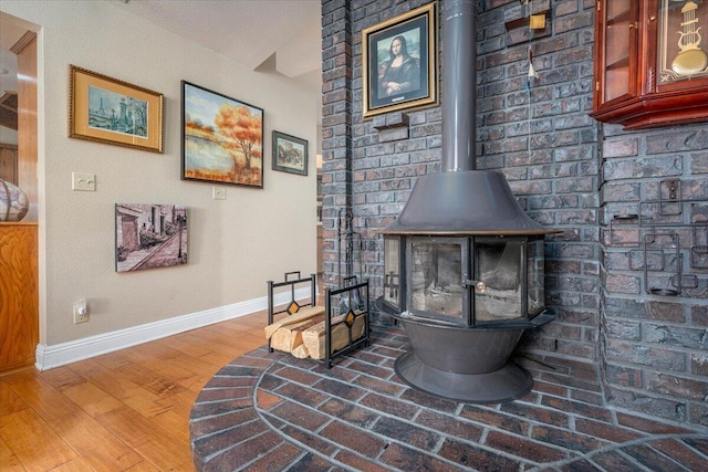 interior details featuring a wood stove and hardwood / wood-style floors