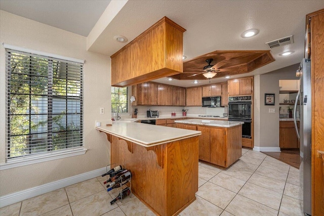 kitchen featuring kitchen peninsula, light tile patterned floors, ceiling fan, and black appliances