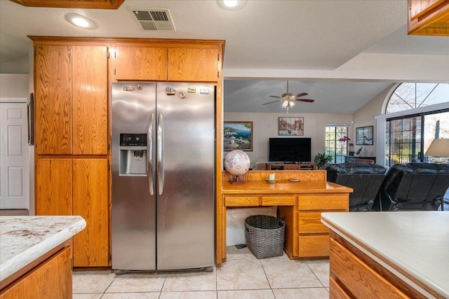 kitchen with ceiling fan, light tile patterned floors, stainless steel refrigerator with ice dispenser, and vaulted ceiling