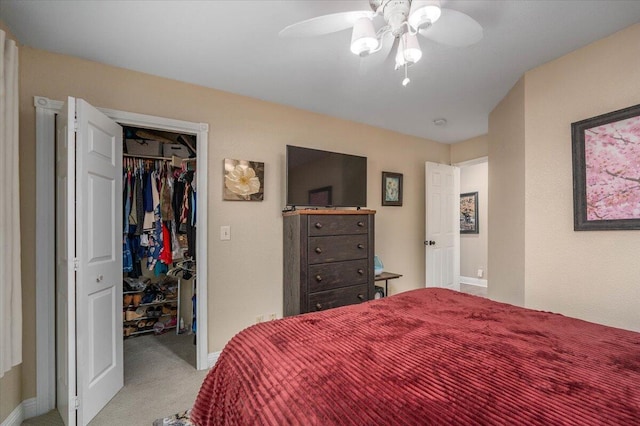 bedroom with ceiling fan, light colored carpet, and a closet