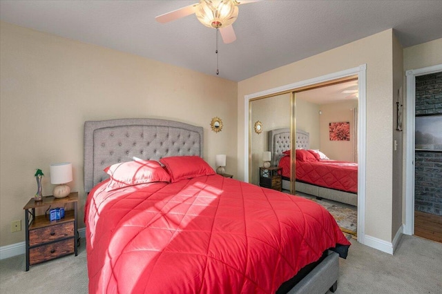 carpeted bedroom with ceiling fan and a closet