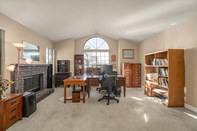 carpeted office space featuring a fireplace and vaulted ceiling