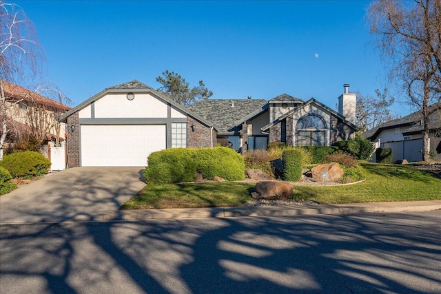 tudor house featuring a garage and a front yard