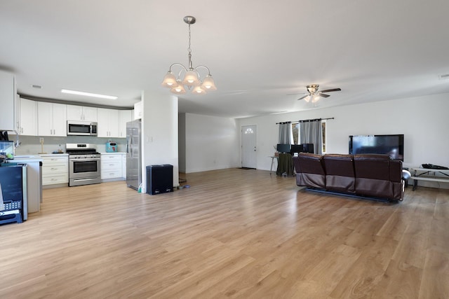 kitchen featuring white cabinetry, hanging light fixtures, light hardwood / wood-style flooring, appliances with stainless steel finishes, and ceiling fan with notable chandelier