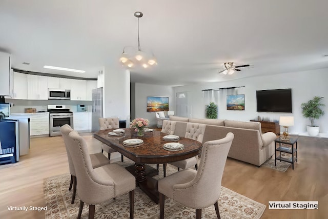 dining room with ceiling fan and light hardwood / wood-style flooring