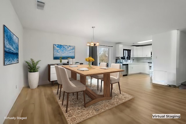 dining area featuring an inviting chandelier and light hardwood / wood-style floors