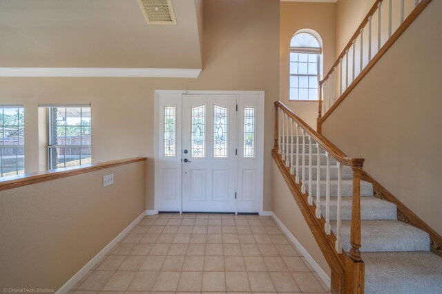 entryway with light tile patterned floors and a high ceiling