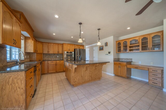 kitchen with a center island, tasteful backsplash, dark stone countertops, decorative light fixtures, and appliances with stainless steel finishes