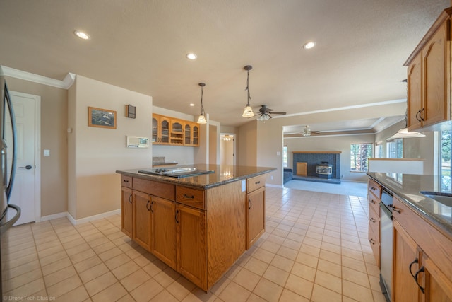 kitchen with ceiling fan, light tile patterned floors, dark stone counters, a kitchen island, and ornamental molding