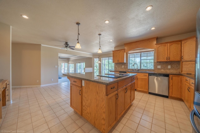 kitchen with backsplash, stainless steel dishwasher, ceiling fan, decorative light fixtures, and a kitchen island