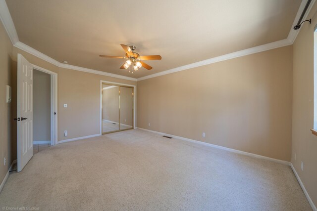 unfurnished bedroom featuring a closet, ceiling fan, and crown molding