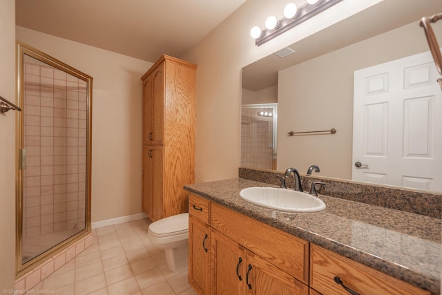 bathroom featuring tile patterned flooring, vanity, a shower with door, and toilet