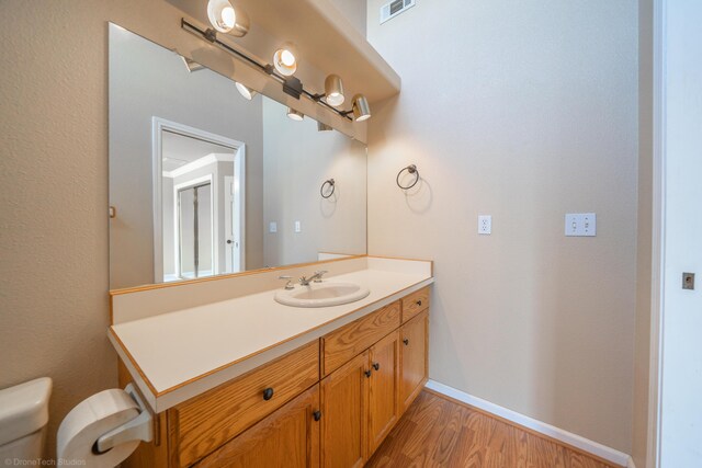 bathroom featuring hardwood / wood-style floors, vanity, and toilet