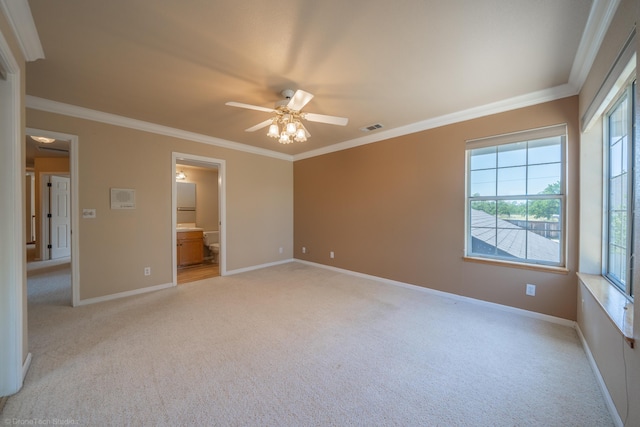 unfurnished bedroom featuring ceiling fan, crown molding, light colored carpet, and ensuite bathroom