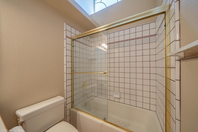 bathroom featuring enclosed tub / shower combo and toilet