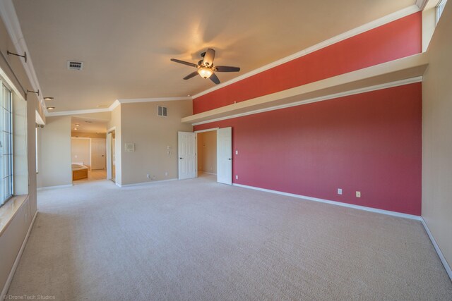 spare room featuring ceiling fan, lofted ceiling, crown molding, and light carpet