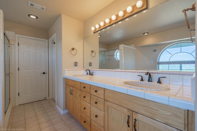 bathroom with tile patterned flooring, vanity, and an enclosed shower