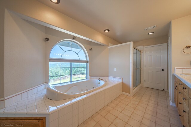 bathroom featuring plus walk in shower, vanity, and tile patterned floors