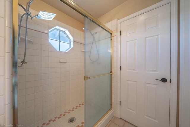 bathroom featuring tile patterned flooring and a shower with shower door