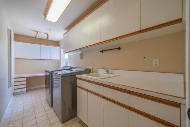 kitchen featuring separate washer and dryer, white cabinetry, sink, and light tile patterned floors