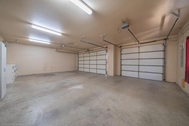 garage featuring electric panel and a garage door opener