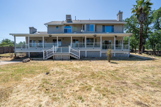 rear view of property with central AC unit, a porch, and a yard