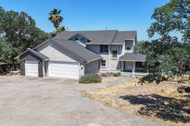 view of property featuring covered porch and a garage