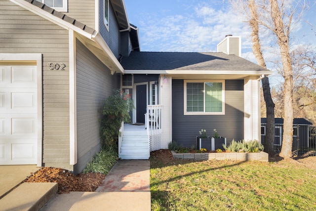 doorway to property featuring a lawn and a garage