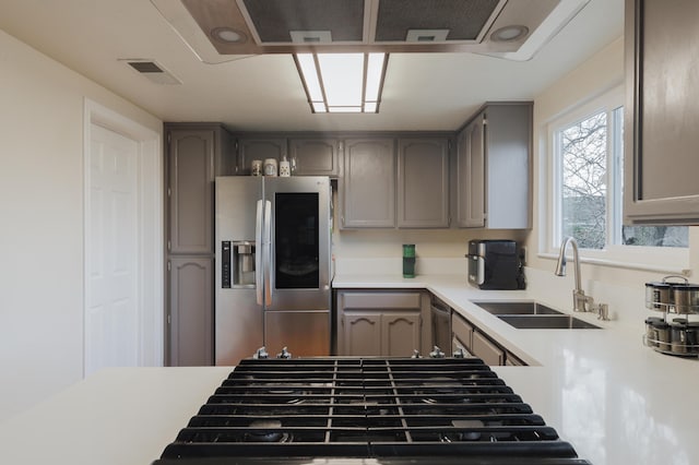 kitchen with gray cabinets, stainless steel fridge, and sink