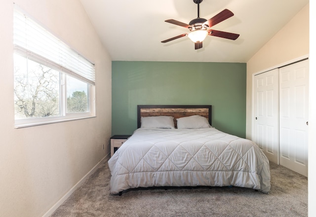 carpeted bedroom with ceiling fan, lofted ceiling, and a closet