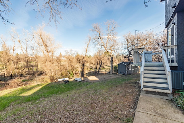 view of yard featuring a wooden deck and a storage shed