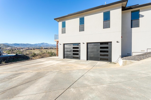 view of side of home with a garage and a mountain view