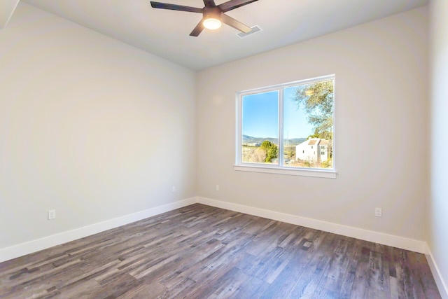 empty room with ceiling fan and dark hardwood / wood-style flooring