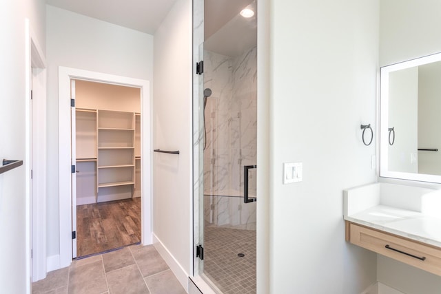 bathroom featuring vanity and a shower with door