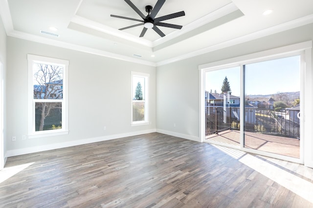 unfurnished room with ceiling fan, crown molding, hardwood / wood-style flooring, and a tray ceiling