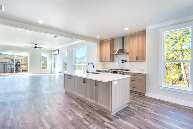 kitchen featuring hardwood / wood-style flooring, sink, pendant lighting, and wall chimney exhaust hood