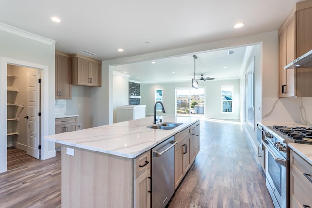 kitchen featuring appliances with stainless steel finishes, an island with sink, light brown cabinets, and sink