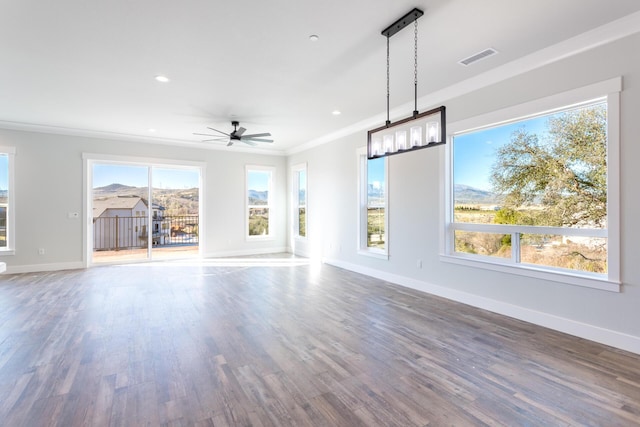 unfurnished living room with ceiling fan, dark wood-type flooring, and crown molding