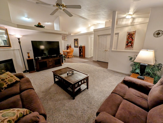 living room with a tile fireplace, light carpet, vaulted ceiling, and ceiling fan