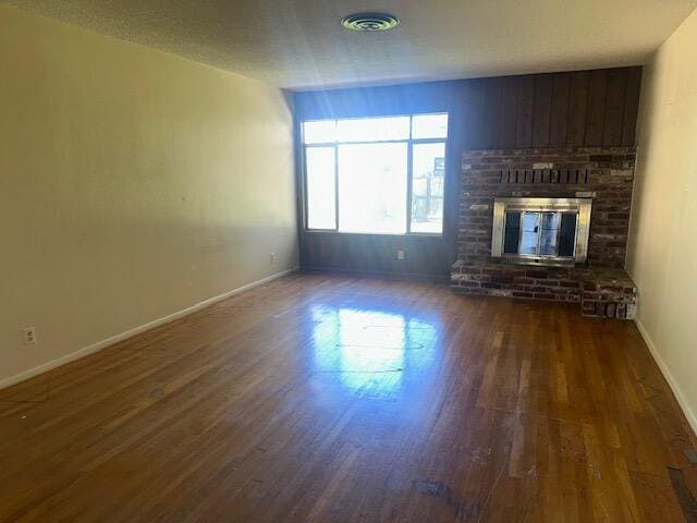 unfurnished living room featuring a fireplace and dark hardwood / wood-style floors