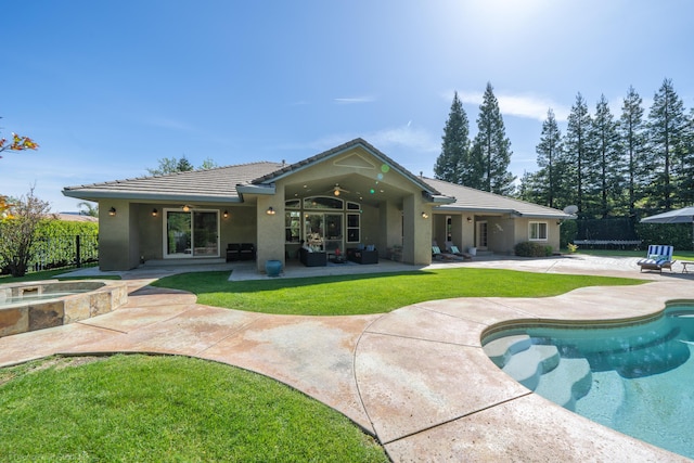 back of property with a swimming pool with hot tub and a patio area