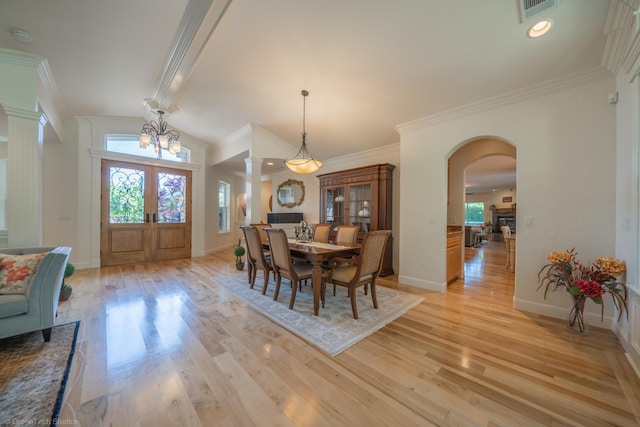 dining room featuring a notable chandelier, light hardwood / wood-style flooring, crown molding, and french doors