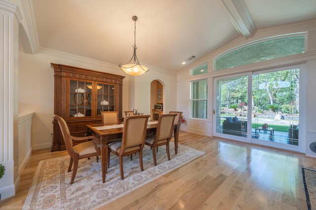 dining room with vaulted ceiling with beams, light hardwood / wood-style floors, and ornamental molding