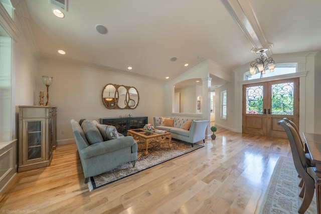 living room featuring ornate columns, french doors, ornamental molding, and light wood-type flooring