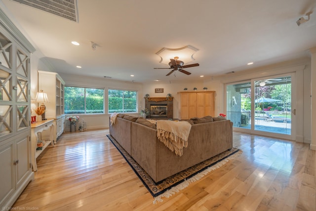 living room featuring ceiling fan, a healthy amount of sunlight, and light wood-type flooring