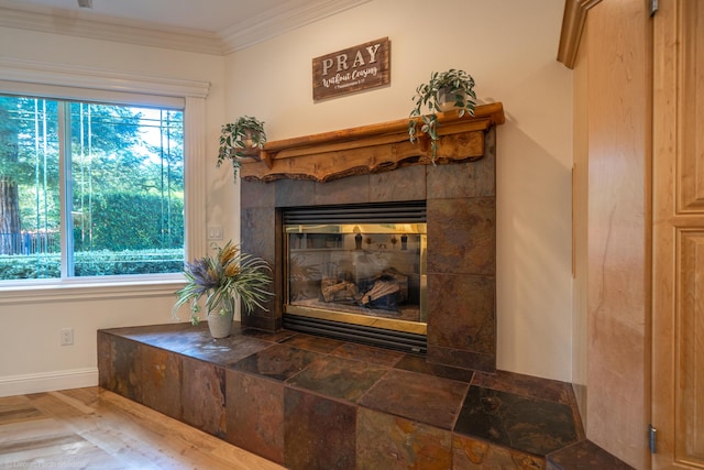 interior details featuring ornamental molding and a tile fireplace