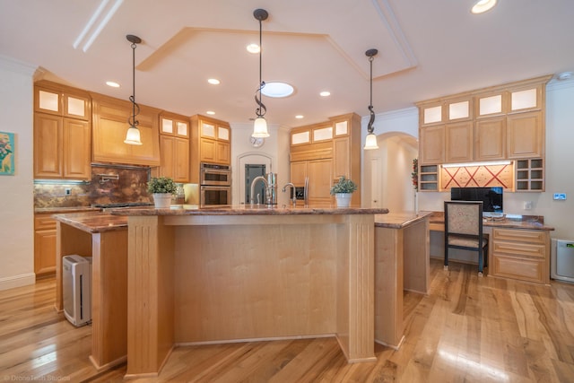 kitchen with pendant lighting, crown molding, a kitchen island with sink, and appliances with stainless steel finishes