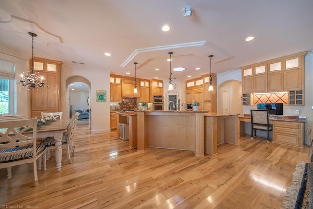 kitchen with pendant lighting, a spacious island, ornamental molding, and tasteful backsplash